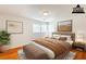 Staged bedroom with warm tones and a plush bed accented by striking artwork and sunlit windows at 3435 Macland Rd, Powder Springs, GA 30127