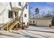 Back of house featuring wood steps leading to the yard and detached garage at 510 Forest St, Buford, GA 30518