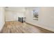 Hallway with hardwood floors, natural light from window, and black metal staircase railing at 510 Forest St, Buford, GA 30518