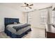 Spacious bedroom with a blue tufted headboard, ceiling fan and two bright windows at 2510 Thorngate Dr, Acworth, GA 30101
