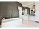 Contemporary bathroom features a freestanding tub, tiled wall, and vanity with decorative lighting at 3376 Peachtree Ne Rd # 56, Atlanta, GA 30326