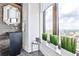 Powder room featuring stone sink, modern mirror, and decorative plants with a cityscape view at 3376 Peachtree Ne Rd # 56, Atlanta, GA 30326