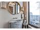 Modern powder room features a decorative vessel sink, stylish mirror, and a bright window with a cityscape view at 3376 Peachtree Ne Rd # 56, Atlanta, GA 30326
