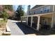 Home's exterior showing an extended covered patio, tan siding, string lights, and a gravel driveway at 4845 Dartford Dr, Powder Springs, GA 30127