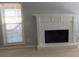 Close up of a painted brick fireplace with a white mantel and a window with blinds on the left side at 4845 Dartford Dr, Powder Springs, GA 30127