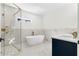 Beautiful bathroom featuring a soaking tub, walk-in shower, and white marble-look tile at 561 Ashburton Ave, Decatur, GA 30032