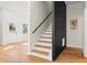 Modern staircase with sleek black railings and hardwood steps, adding architectural interest to the foyer at 561 Ashburton Ave, Decatur, GA 30032