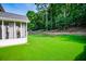 Manicured backyard with a lush lawn, a privacy fence with mature trees, and a covered patio attached to the house at 613 Hemlock Ct, Villa Rica, GA 30180