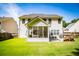 Rear exterior view of the home shows a lush backyard with a covered patio and a screened porch for relaxing outdoors at 613 Hemlock Ct, Villa Rica, GA 30180