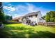 Expansive backyard features lush grass, a privacy fence, a patio with potted plants, and a covered porch for outdoor living at 613 Hemlock Ct, Villa Rica, GA 30180