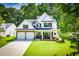 Charming two-story home featuring a covered front porch, stone accents, and a well-manicured lawn at 613 Hemlock Ct, Villa Rica, GA 30180