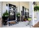 Inviting front porch decor with a magnolia wreath, potted ferns, and American flag accents at 613 Hemlock Ct, Villa Rica, GA 30180
