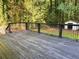 View of the dark wood back deck surrounded by lush greenery with a shed in the background at 5531 Four Winds Sw Dr, Lilburn, GA 30047