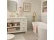 Bathroom boasts a white vanity, freestanding tub, gold fixtures, and light filled elegant design at 5531 Four Winds Sw Dr, Lilburn, GA 30047