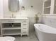 Bathroom features a white vanity, freestanding tub, gold fixtures, and elegant textured walls at 5531 Four Winds Sw Dr, Lilburn, GA 30047