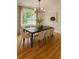 Dining room with large window, wainscoting, hardwood floors, modern chandelier, and seating for eight at 5531 Four Winds Sw Dr, Lilburn, GA 30047