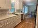 Updated kitchen features white cabinets, stone backsplash, stainless steel sink and hardwood floors at 5531 Four Winds Sw Dr, Lilburn, GA 30047