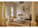 Living room with decorative columns, wainscoting, wood flooring, neutral furniture, and lots of light at 5531 Four Winds Sw Dr, Lilburn, GA 30047