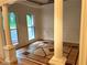 Bright living room with decorative columns, wainscoting, custom wood flooring, and view to the outdoors at 5531 Four Winds Sw Dr, Lilburn, GA 30047