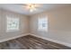 Sunny bedroom featuring wood-look floors, neutral walls, and two windows for ample light at 1376 Westmont Sw Rd, Atlanta, GA 30311