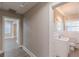 This hallway features grey floors and opens to a bathroom with a white vanity and a round mirror at 1376 Westmont Sw Rd, Atlanta, GA 30311
