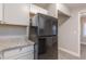 A kitchen featuring a black refrigerator, granite counters, and white cabinets, blending style with functionality at 1376 Westmont Sw Rd, Atlanta, GA 30311