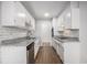 Well-lit kitchen with white cabinets, granite countertops, tile backsplash, and wooden floors at 3080 Forrest Park Road Se, Atlanta, GA 30354