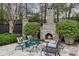 Outdoor stone fireplace with seating area, perfect for cozy evenings and entertaining in a landscaped backyard at 80 26Th Nw St, Atlanta, GA 30309