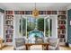 Bright sitting area featuring built-in bookshelves and french doors with view of pool and outdoor greenery at 80 26Th Nw St, Atlanta, GA 30309