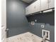 A well-organized laundry room features overhead cabinets, a modern vent system, and sleek marble-like flooring at 830 Corsiglia Farm, Marietta, GA 30060