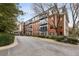 Brick apartment building featuring multiple balconies and a tree lined parking area at 2921 Lenox Ne Rd # 310, Atlanta, GA 30324