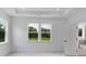 Bright bedroom with large windows offering lush green views, tray ceiling and an open door to the bath at 1356 Auburn Glen Rd, Dacula, GA 30019