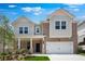 Charming two-story home featuring a brick facade, white trim, a covered porch, and a two-car garage at 1356 Auburn Glen Rd, Dacula, GA 30019