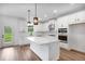 Bright kitchen with white cabinets, stainless steel appliances, a large island, and views of the backyard at 1356 Auburn Glen Rd, Dacula, GA 30019