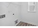 A laundry room with wood style flooring, utility sink hookups, and wire rack shelving at 1356 Auburn Glen Rd, Dacula, GA 30019