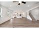 Spacious living area featuring hardwood floors, bright windows, a ceiling fan, and an open view to the kitchen at 1356 Auburn Glen Rd, Dacula, GA 30019