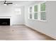Bright living room with large windows, hardwood floors, and a cozy fireplace at 1356 Auburn Glen Rd, Dacula, GA 30019