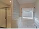 A relaxing bathroom features a soaking tub, stylish shiplap accent wall and glass enclosed shower at 207 Tan Yard Rd, Social Circle, GA 30025