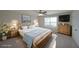 A cozy staged bedroom with a wooden bed frame, carpet floors, and a window for natural light at 207 Tan Yard Rd, Social Circle, GA 30025