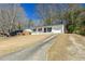 Charming white ranch-style home with a long driveway and well-manicured lawn at 4558 Ryan Rd, Conley, GA 30288