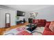 Cozy living room with hardwood floors, red sofas, and a modern black coffee table at 4558 Ryan Rd, Conley, GA 30288