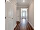 Elegant hallway with hardwood floors, crown molding, and recessed lighting leading to a bright entrance at 2628 Songbird Ln, Grayson, GA 30017