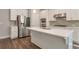 Modern kitchen with stainless steel refrigerator, white cabinets, and large island at 2628 Songbird Ln, Grayson, GA 30017