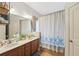 Bathroom featuring double sinks, wooden cabinets, a bathtub with shower, providing ample space and functionality at 2845 Hickory Cir, Snellville, GA 30078