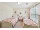 Charming bedroom featuring two twin beds with pink linens and a matching bedside table at 2845 Hickory Cir, Snellville, GA 30078