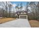 Beautiful home featuring an attached garage, long driveway, and basketball court, nestled amongst mature trees at 2845 Hickory Cir, Snellville, GA 30078