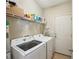 Functional laundry room equipped with a washer, dryer, storage shelves, and convenient access to the exterior, streamlining chores at 2845 Hickory Cir, Snellville, GA 30078