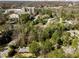 Aerial view of property showcasing lush trees, landscaped grounds, and city skyline in the distance at 3240 Pinestream Nw Rd, Atlanta, GA 30327