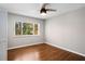 Cozy bedroom with hardwood floors, a ceiling fan, and a large window for natural light at 3240 Pinestream Nw Rd, Atlanta, GA 30327