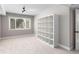 Bedroom featuring a window, neutral carpet, and a built-in shelving unit at 3240 Pinestream Nw Rd, Atlanta, GA 30327